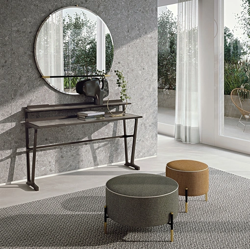 Pouf Kevin in tessuto imbottito con base leggera in metallo con dettagli in contrasto di Frigerio