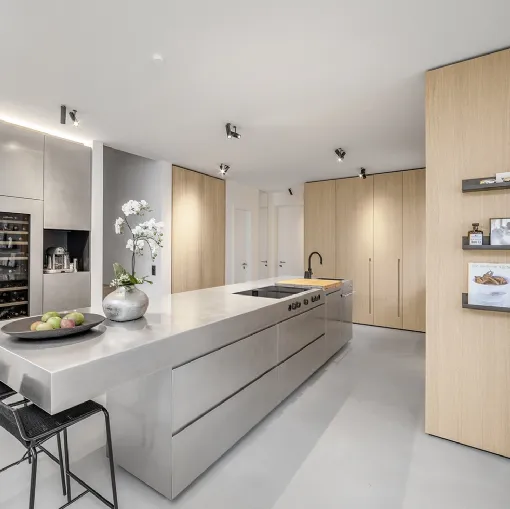 Cucina Design Metropolitan Interiors con isola interamente rivestita in acciaio inox e boiserie in legno di rovere di Mittel